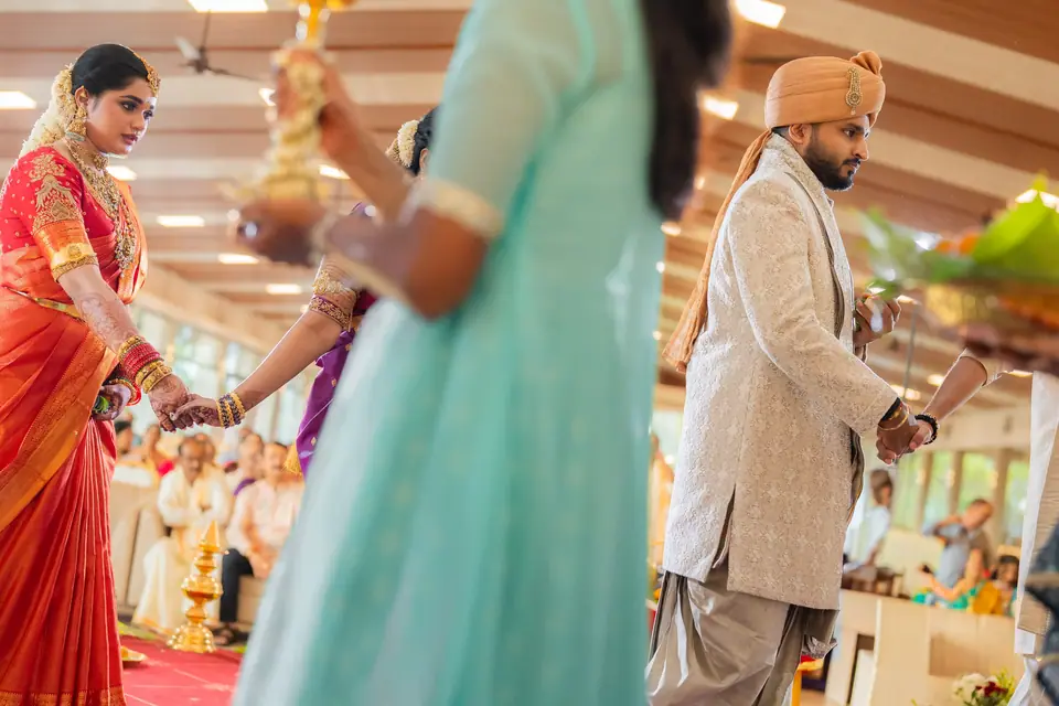 The ceremony seen through guests, the couple facing each other across the hall