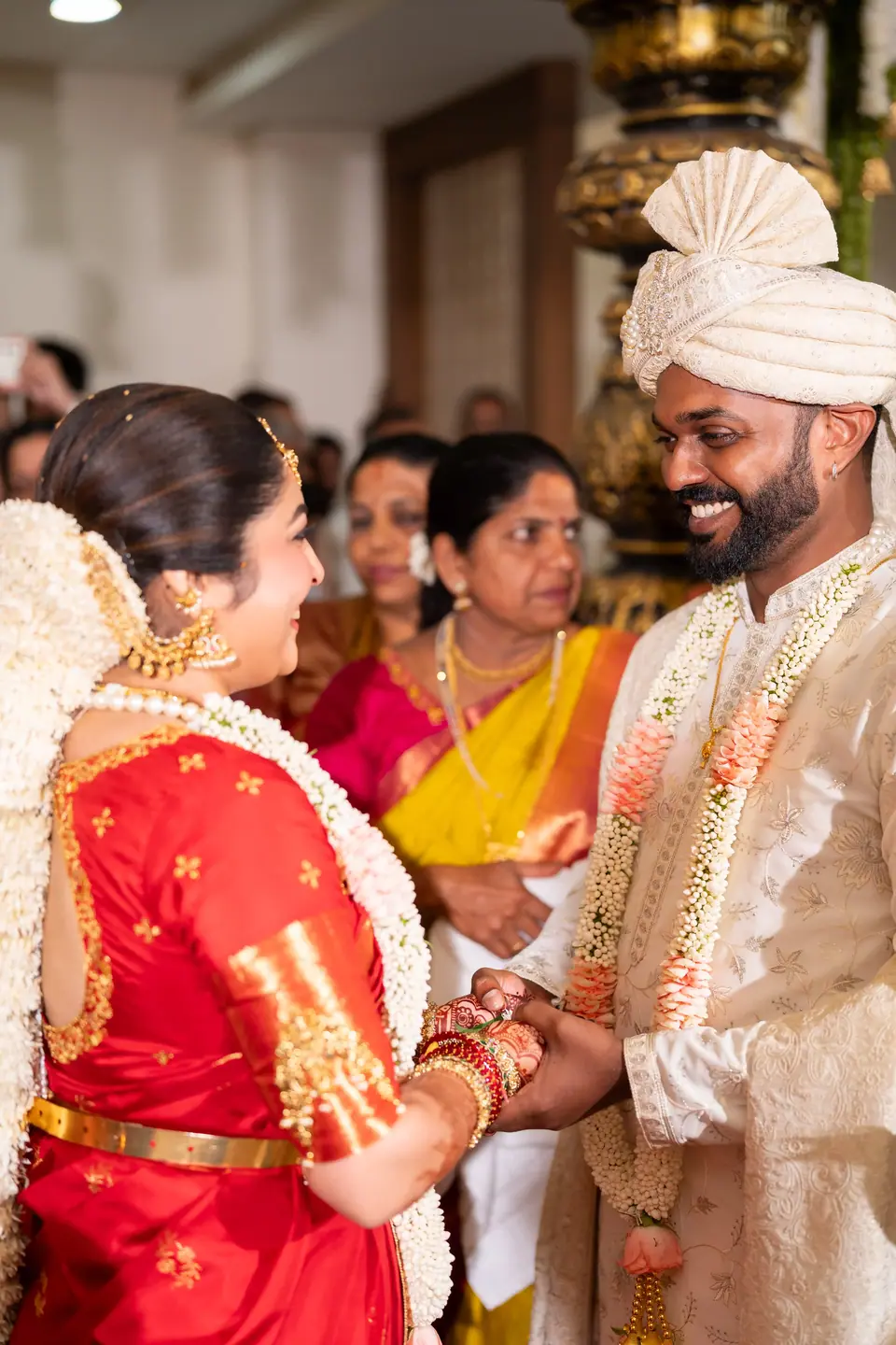 The bride laughing as the couple exchange garlands among family