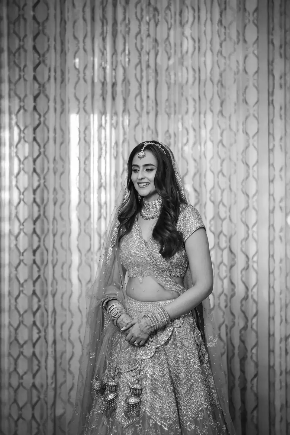 Black and white: the bride standing before patterned curtains