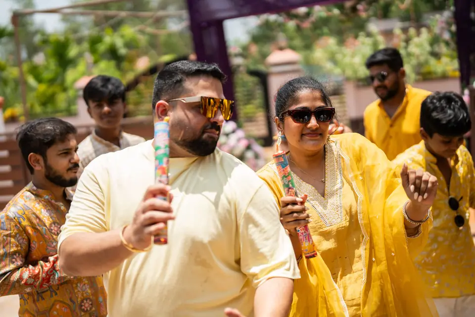 Guests in yellow dancing and celebrating under the afternoon sun