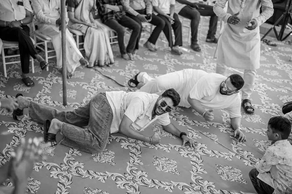 Black and white: two guests lying on the patterned floor, laughing