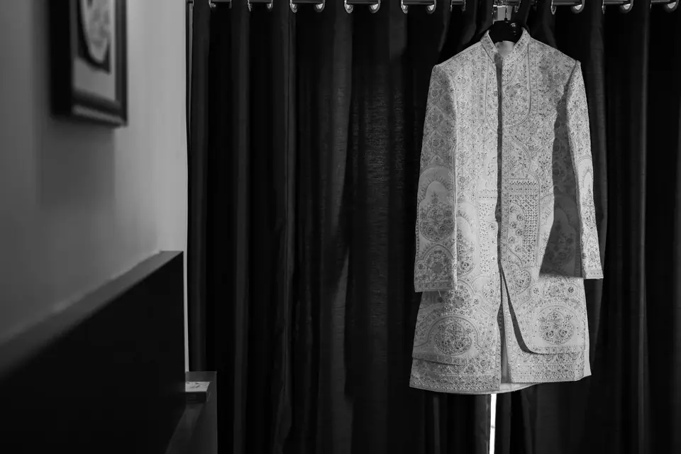 Black and white: an embroidered sherwani hanging in a quiet room