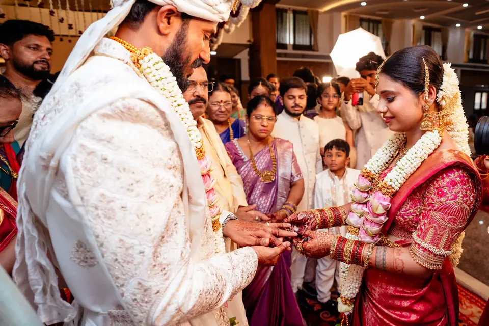 The couple exchanging rings among family