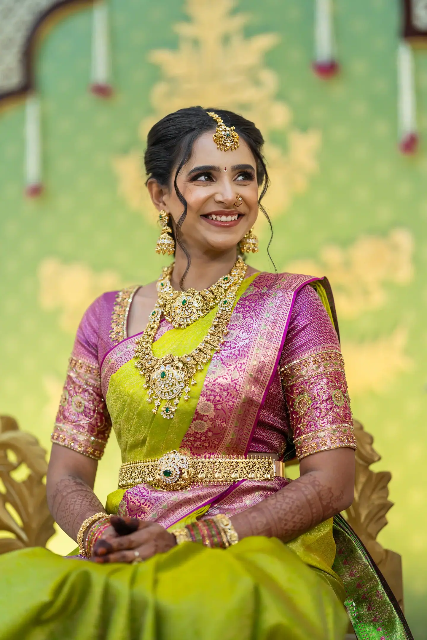 The bride in pink and lime silk before a painted wall