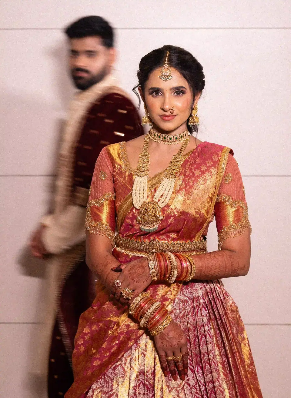 The bride standing still while the groom passes behind her in a blur