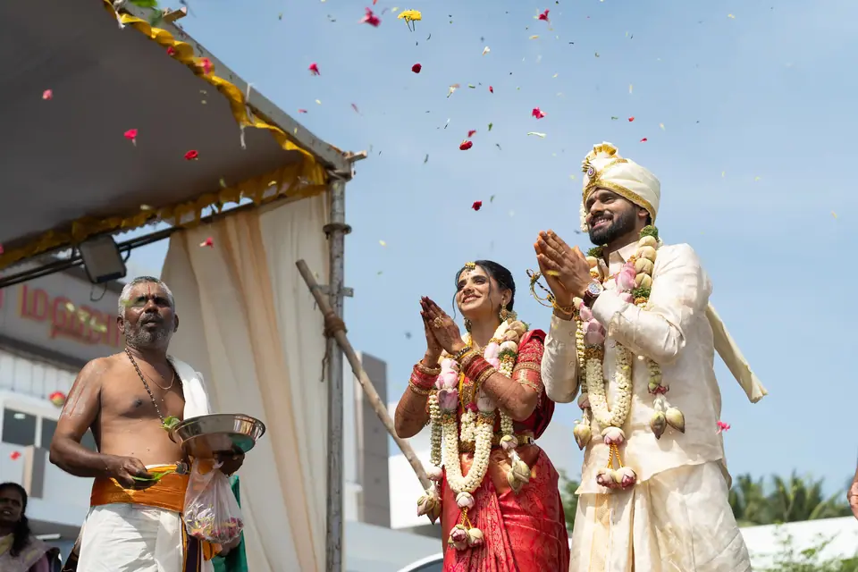 Petals thrown over the couple under a bright blue sky
