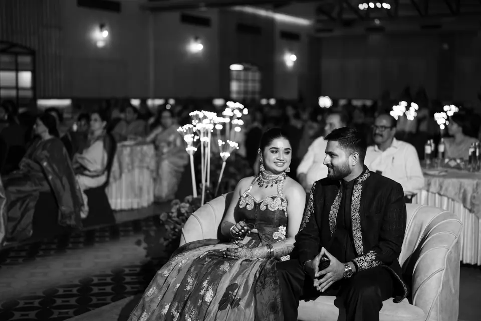 Black and white: the couple seated on a sofa among the guests