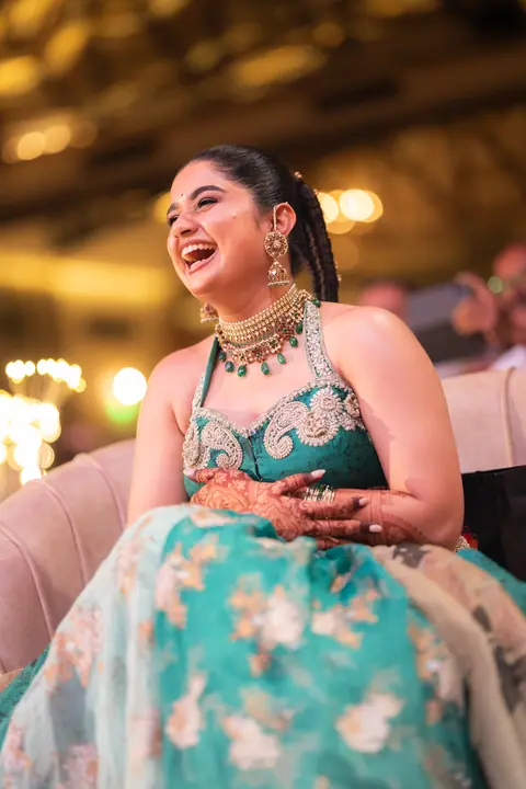 Shreya in teal silk laughing out loud at the sangeet