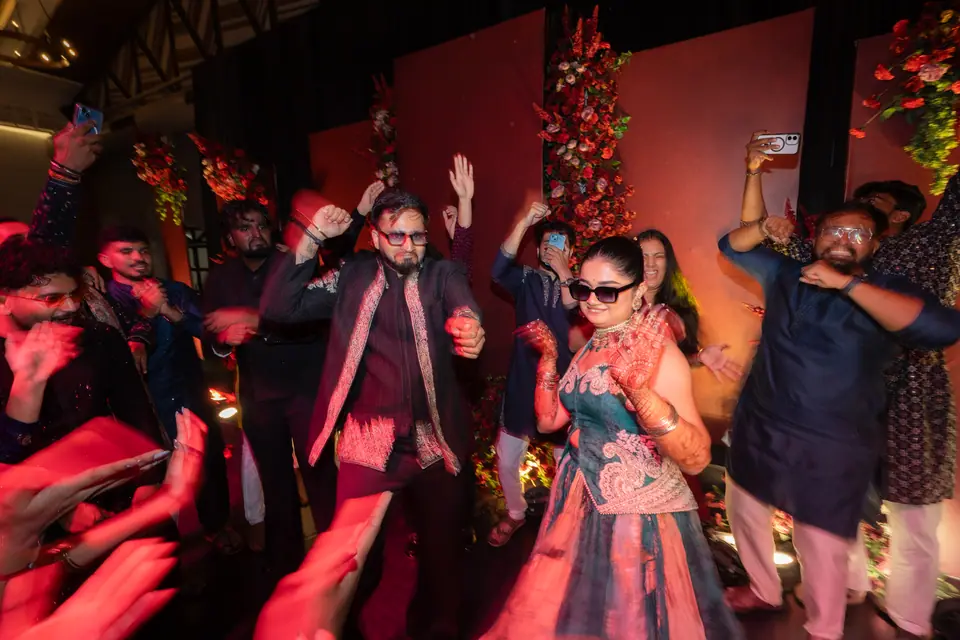 The couple in the middle of a crowded dance floor, hands in the air